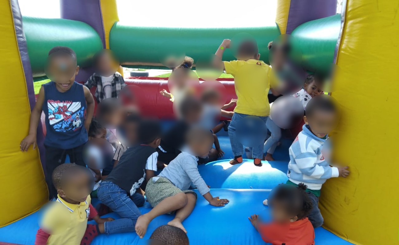Toddlers playing on a jumping castle. Children's faces are blurred.