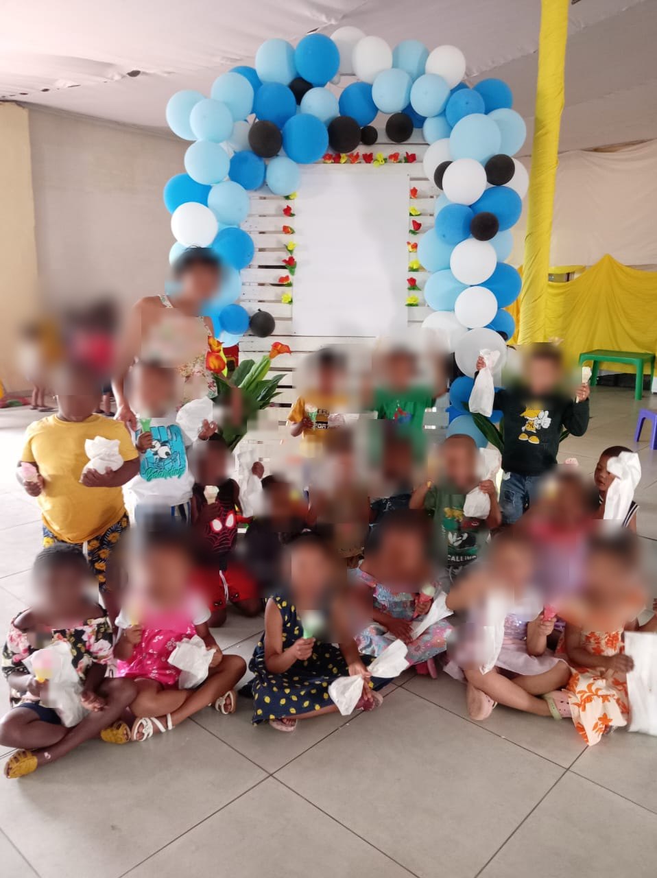 A practitioner with the older children at Little Wonder. Children's faces are blurred.