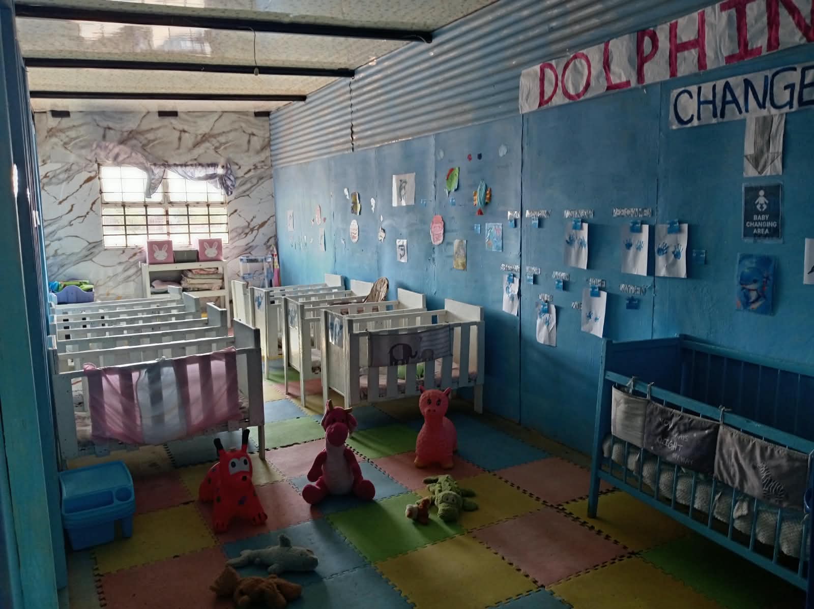 The baby room at Little Wonder, with cots and soft play mats